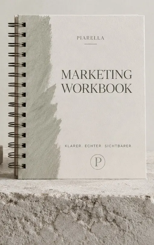 Spiralgebundenes Marketing Workbook von Piarella auf einer hellen Steinfläche